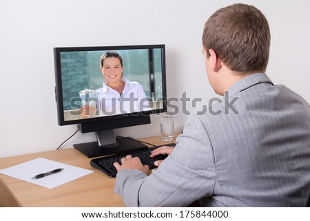 back view of young businessman working in internet in his office