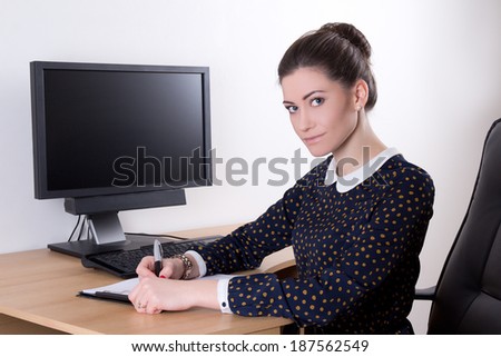 young beautiful business woman in office using computer with empty monitor screen