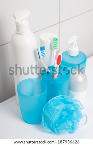 collection of blue hygiene supplies over tiled wall in bathroom