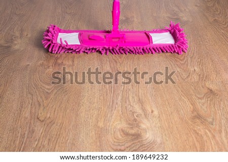 close up of wooden floor with pink cleaning mop