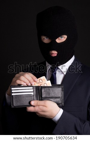 man in business suit and black mask holding leather purse with euro banknotes