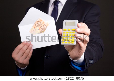 envelope with euro banknotes and calculator in business man hands