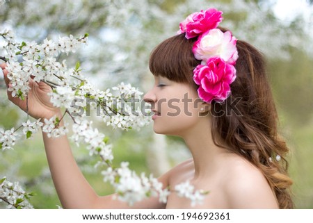 young pretty woman smell  blooming tree in garden