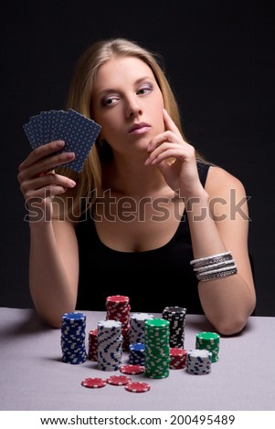 young attractive beautiful serious woman playing poker in casino