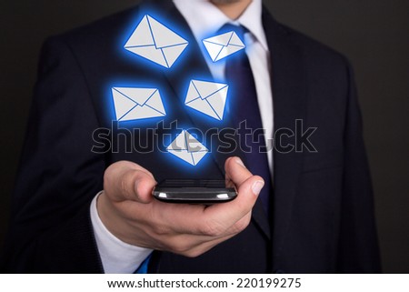 modern smart phone in business man hand and flying envelopes