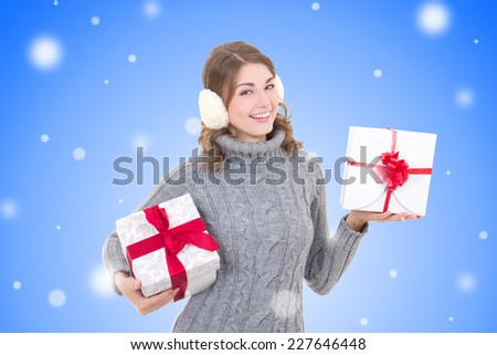 happy attractive woman in woolen sweater and muffs with christmas presents over christmas background