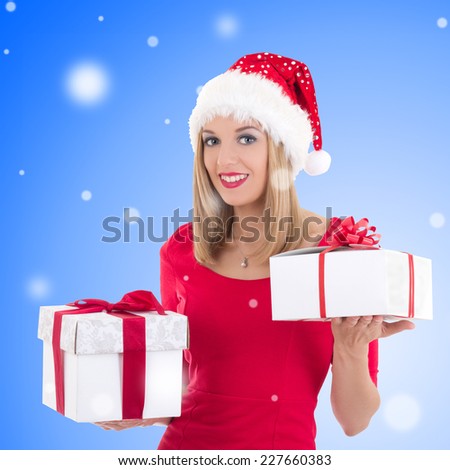 portrait of attractive happy woman in santa hat posing with gift boxes over christmas background