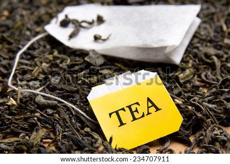 close up picture of tea bag and dried black tea leaves