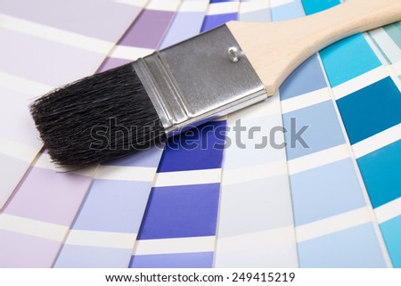 interior design - paint brush over colorful paper palette with vivid colors