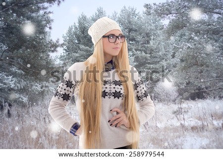 young beautiful woman in winter clothes walking in forest