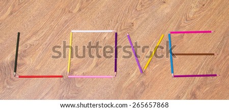 word love made by colorful pencils on wooden table