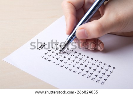 woman filling test score sheet with answers