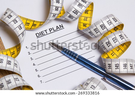 sheet of paper with diet plan, pen and yellow measure tape