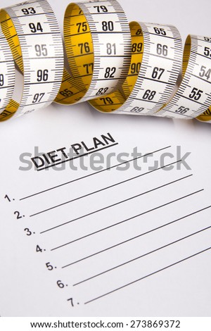 close up of measure tape on paper with diet plan