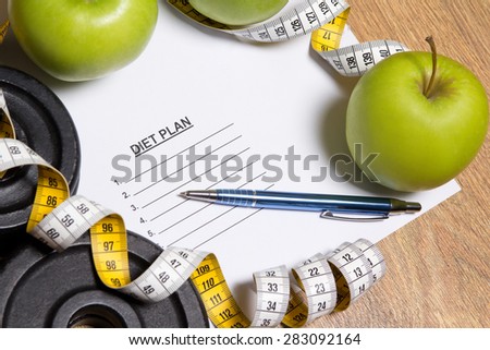 sheet of paper with diet plan, apples, dumbbell and measure tape