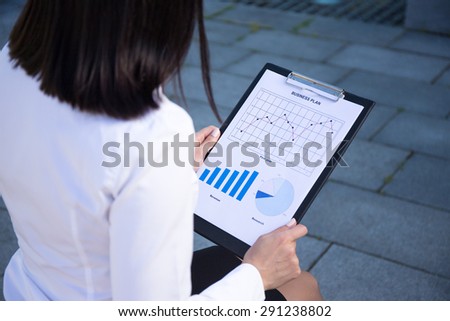 business plan concept - woman holding clipboard with different charts