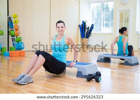 happy young beautiful slim woman working out with stepper in gym