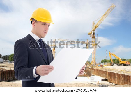 young handsome architect man in builder helmet at construction site