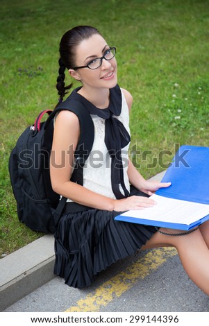 education concept - beautiful school girl or student reading something in summer park