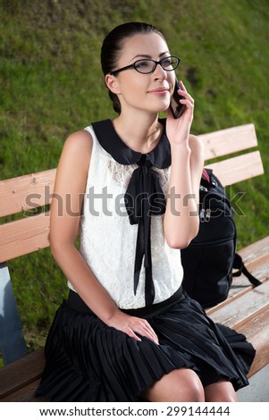 smiling student or school girl talking on mobile phone in summer park