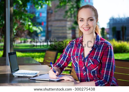 teenage student or school girl doing her homework in summer park