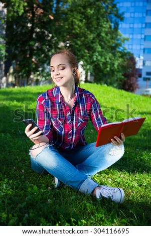 teenage girl with smart phone and book in summer park