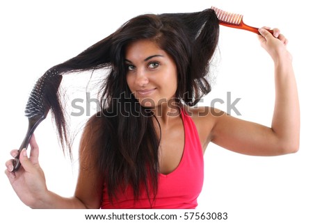 young pretty woman in pink brushing her hair with brush and comb