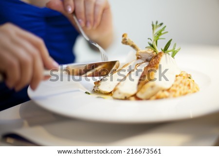 eating chichen from plate with fork and knife woman hands
