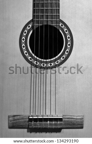 Classical wooden spanish acoustical guitar close-up image, black and white