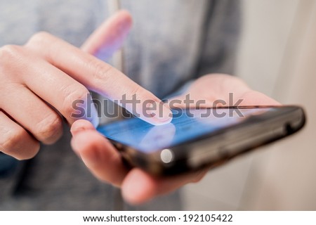 Young girl woman using modern communication holding touchscreen mobile phone on her hand doing sms chat write roll read close up image
