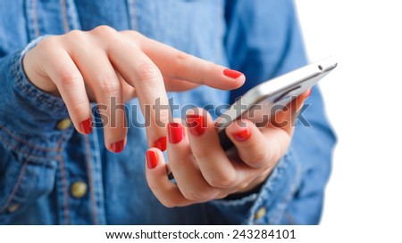 Young woman in blue denim shirt holding touch screen mobile phone in her red nail hands with small depth of field on isolated white background