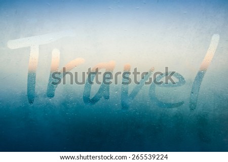 Finger drawn word Travel on bright steamy boat window on sea
