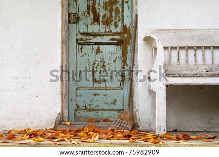 Fall mood: Green door, an old bench, broom, leaf