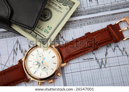 leather wallet cash & gold clock on business graph