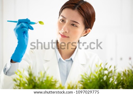 young woman scientist watching a plant