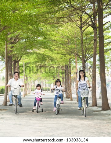 happy family riding bicycle in the park