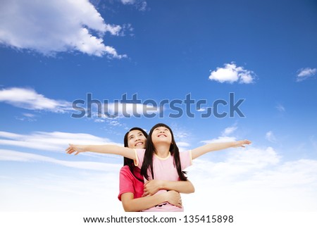 happy little girl and mother watching the sky