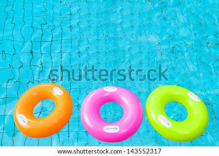 three colorful swimming pool rings on the water