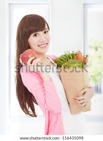 beautiful young woman with apple and vegetables