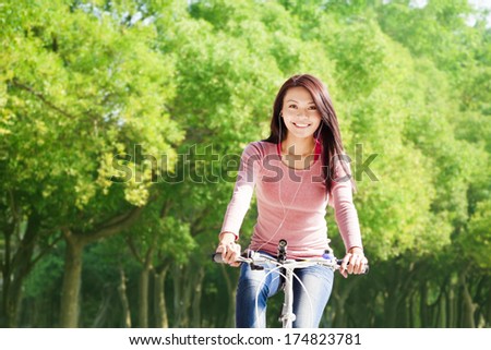 young woman riding bike and listening music