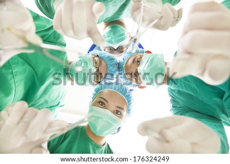 Surgeons and assistant operating with surgical instruments