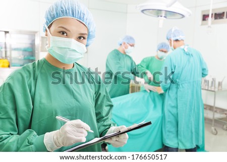 woman Surgeons writing medical record in operation room