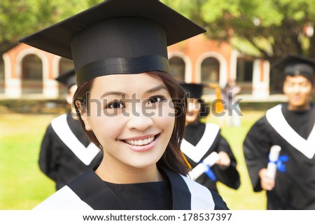 beautiful female college graduate with classmates at ceremony