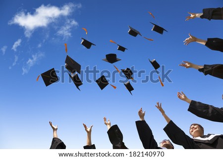 Students throwing graduation hats in the air celebrating Students throwing graduation hats in the air celebrating