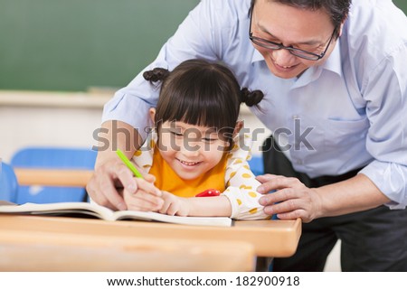 Teacher teaches a student to using a pencil