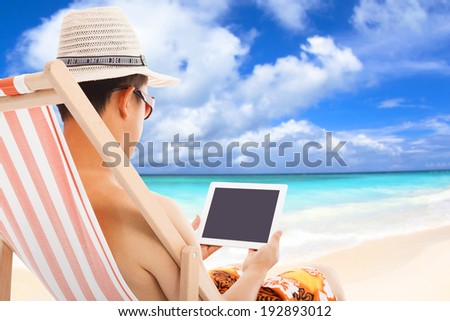 relaxed man sitting on beach chairs and touching tablet