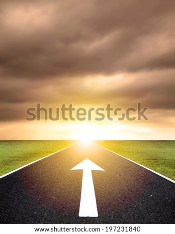 the ahead arrow on the asphalt road  and sunset background