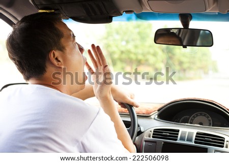 Exhausted driver yawning and driving car on the road.Transportation concept