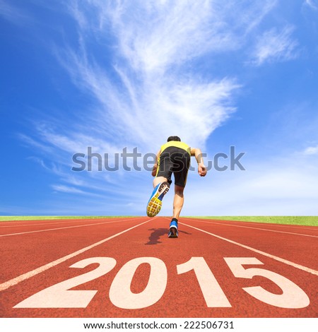 happy new year 2015 young man running on track with blue sky and cloud background happy new year 2015 young man running on track with blue sky and cloud background