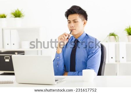 Young business man watching laptop and planning
